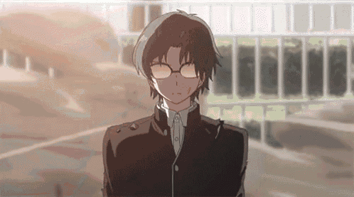 a young boy wearing glasses and a black jacket is standing in front of a building .