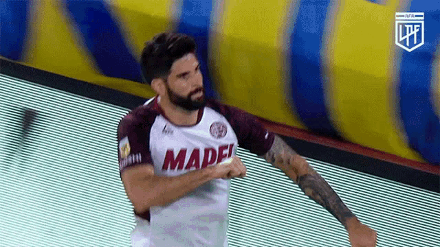 a man with a beard wearing a white and red madef jersey