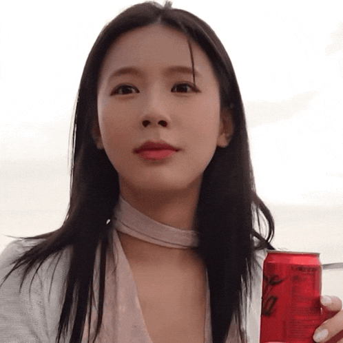 a woman is holding a red can that says ' ginger ale ' on it