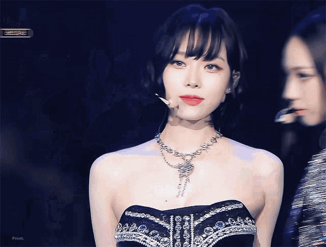 a woman wearing a necklace and a strapless dress with the word feel on the bottom