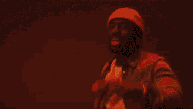 a man in a beanie and leather jacket is dancing