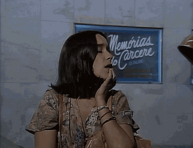 a woman crying in front of a sign that says memoria cancer