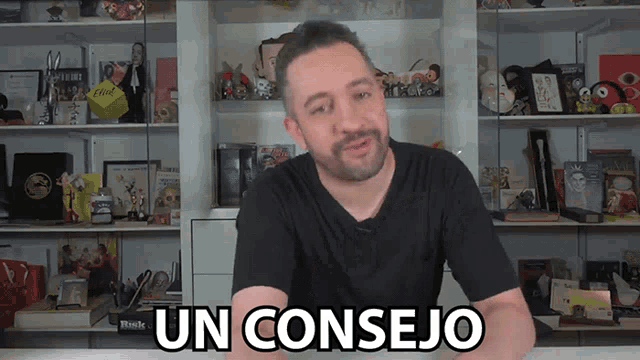 a man in a black shirt says un consejo in front of a shelf full of toys