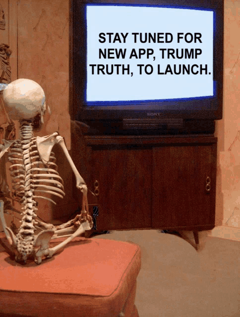 a skeleton sits in front of a sony television with a message that says stay tuned for new app trump truth to launch
