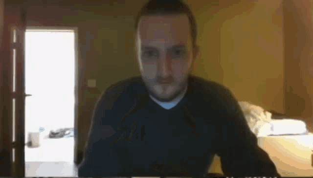 a man with a beard is sitting in front of a computer monitor