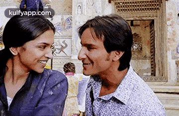a man and a woman are looking at each other and smiling while standing next to each other .