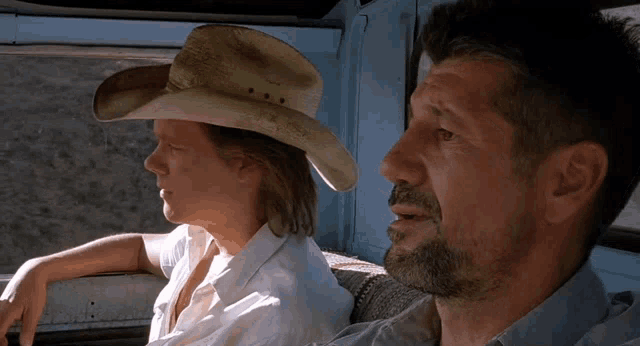 a man in a cowboy hat sits next to a woman