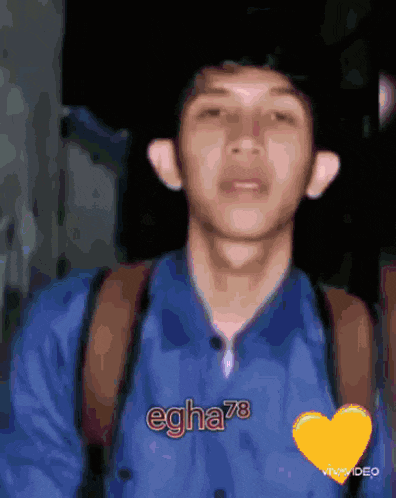 a young man wearing a blue shirt with the name eghe78 on it