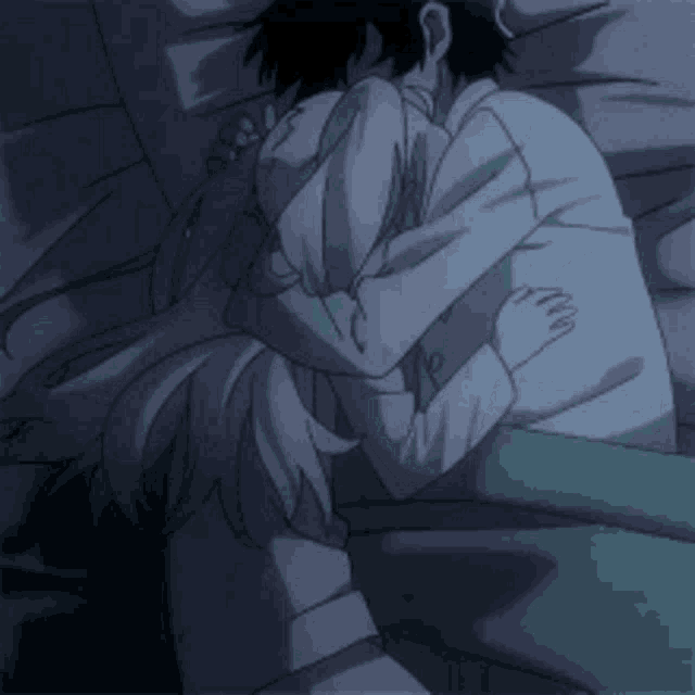 a man and a woman are hugging each other while laying in bed .