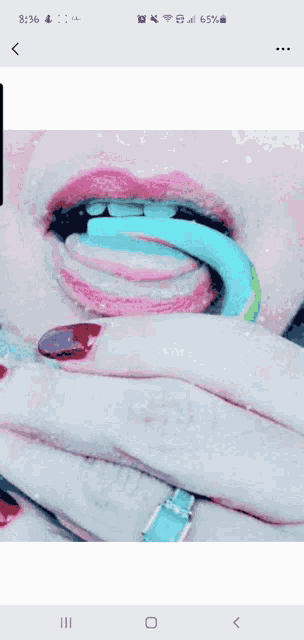 a close up of a woman 's mouth with a blue tongue sticking out ..
