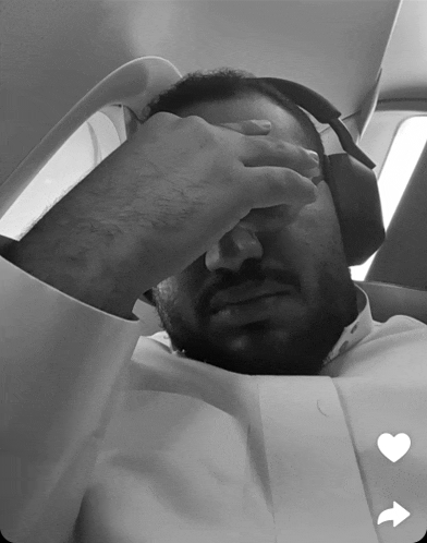 a man wearing headphones is covering his face