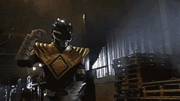 a green ranger is holding a green light saber in his hand .