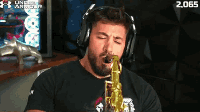 a man wearing headphones plays a saxophone in front of an under armour logo