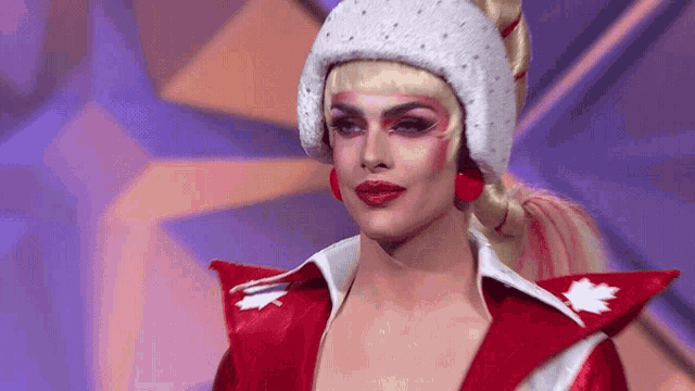 a drag queen is wearing a red and white outfit with a canadian flag on it .