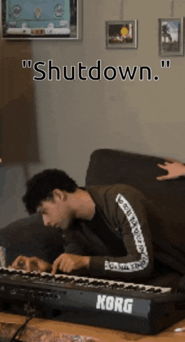 a man sits on a couch playing a korg piano