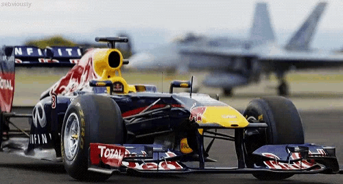 a red bull race car is driving down a road