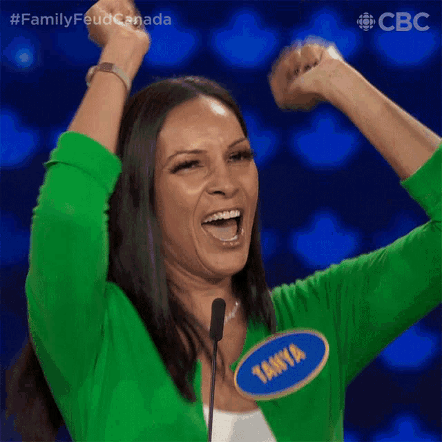 a woman wearing a green sweater with tanya on it