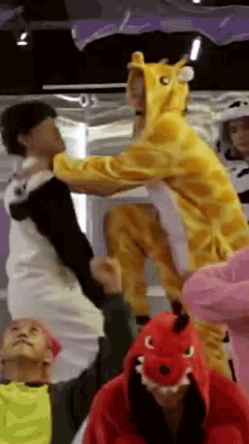 a man in a giraffe costume is holding another man 's hand .