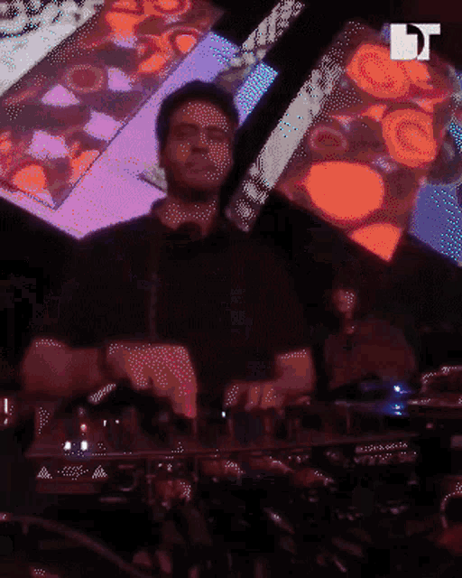 a pixelated image of a man playing a dj set with the letter t in the corner