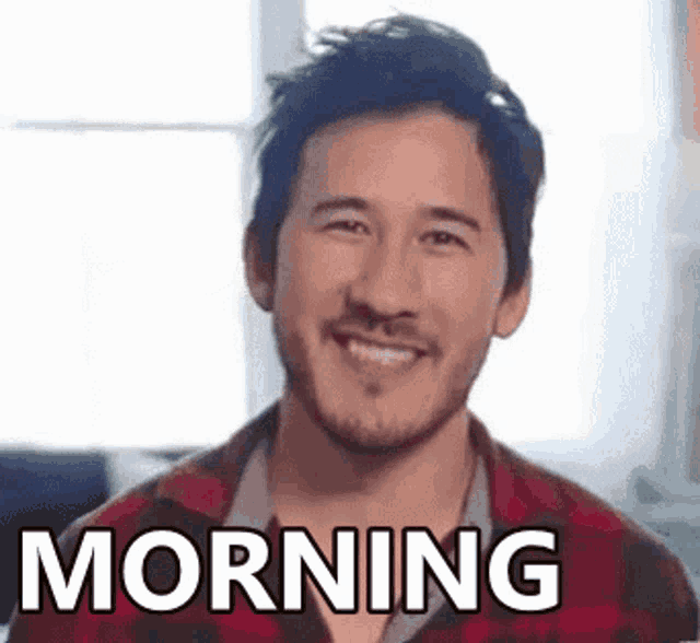 a man with a beard is smiling with the words morning written on his face .