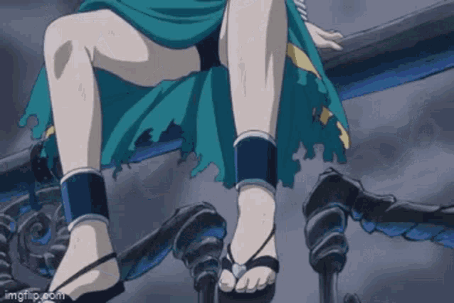 a woman in a blue dress is sitting on a railing with her legs crossed .