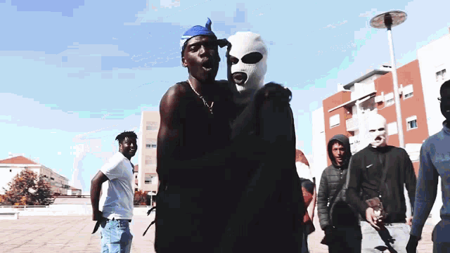 a man in a ski mask is being held by another man in a black jacket