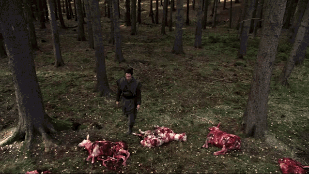 a man standing in the middle of a pile of dead animals