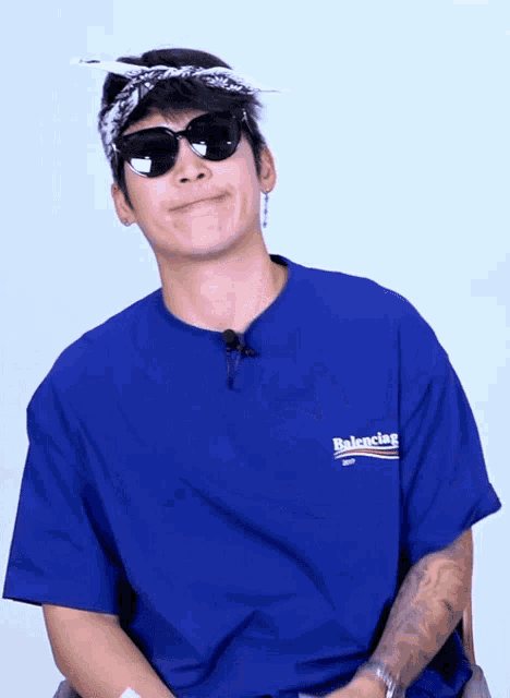 a man wearing sunglasses and a balenciaga shirt