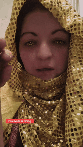 a woman wearing a yellow scarf with the words pov nikki is hiding underneath