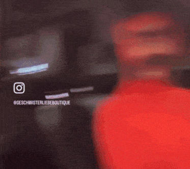 a blurry picture of a person standing in a room with a pink light