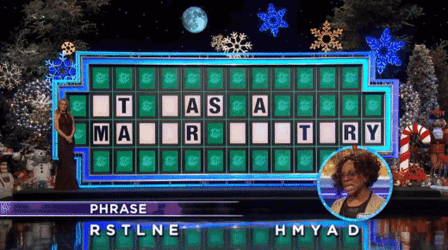 a woman stands in front of a wheel of fortune which has phrase rstlne hmyad on it