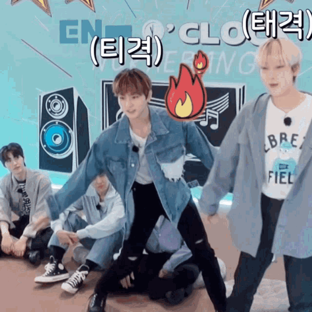 a group of young men are dancing in front of a sign that says ' en ' on it