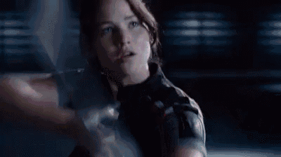 a woman is holding a bow and arrow in her hand and pointing it at something .