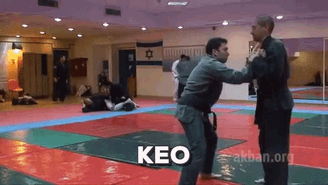 two men are fighting in a gym with the word keo in the corner