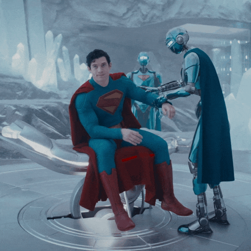 a man in a superman suit sits in a chair