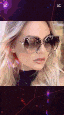a close up of a woman wearing sunglasses with the letter m on the bottom right
