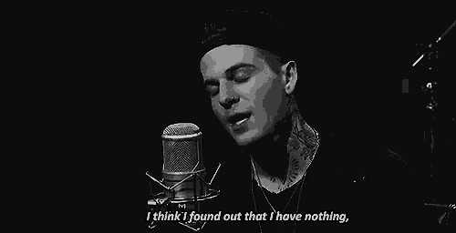a man is singing into a microphone and saying `` i think i found out that i have nothing . ''