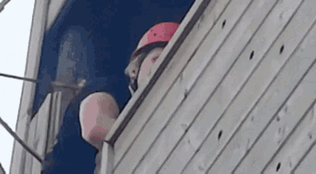 a man wearing a helmet is looking out of a window .