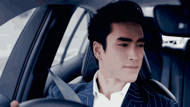 a man in a suit is sitting in a car
