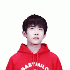 a young man wearing a red baby milo hoodie is giving a thumbs up .