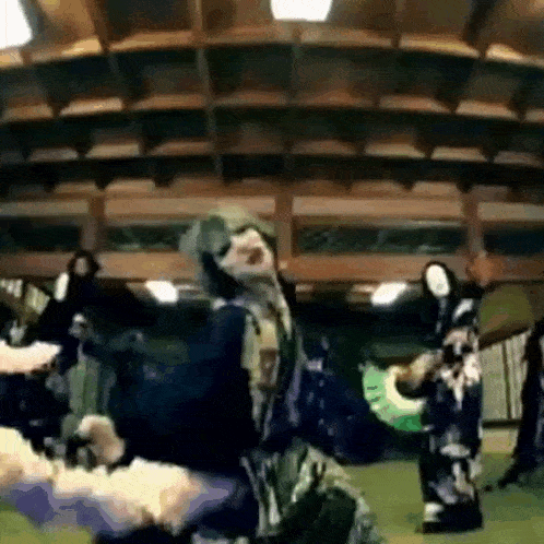 a group of people are dancing in a room with a ceiling that is very high .