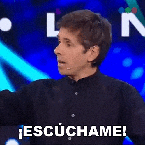 a man in a black shirt is standing in front of a sign that says escuchame