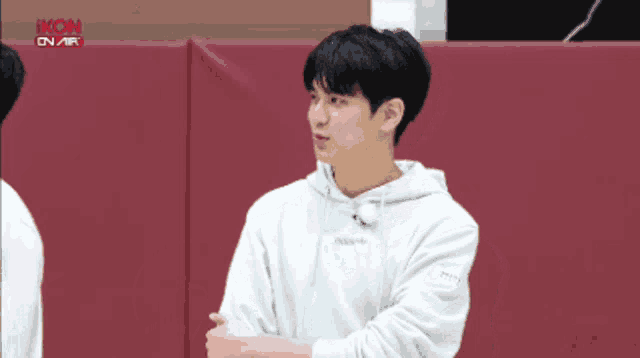 a man wearing a white hoodie with the word ikon on it