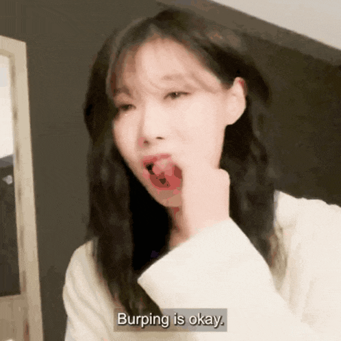a woman says burping is okay while holding her hand to her mouth