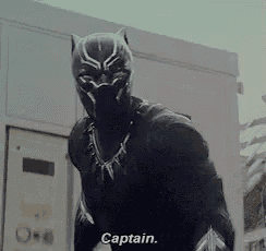 a black panther is standing in front of a building and talking to someone .