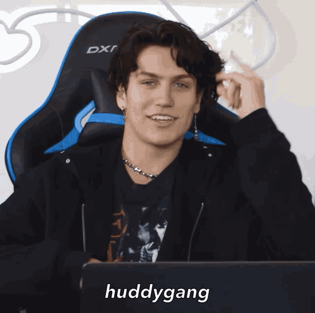 a man sitting in a chair with the word huddygang written on the bottom