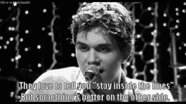 a man is singing into a microphone with a quote .