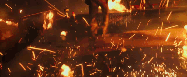 a person is standing in front of a fire that is coming out of a building
