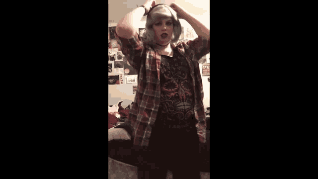 a girl wearing a plaid shirt and a black shirt with a skull on it