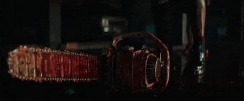 a person holding a bloody chainsaw that says ' slasher ' on it